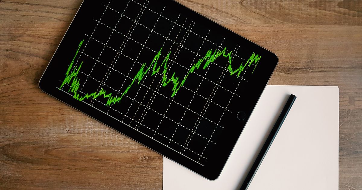 A spreadsheet of B2B contact records open on a laptop screen beside a notebook