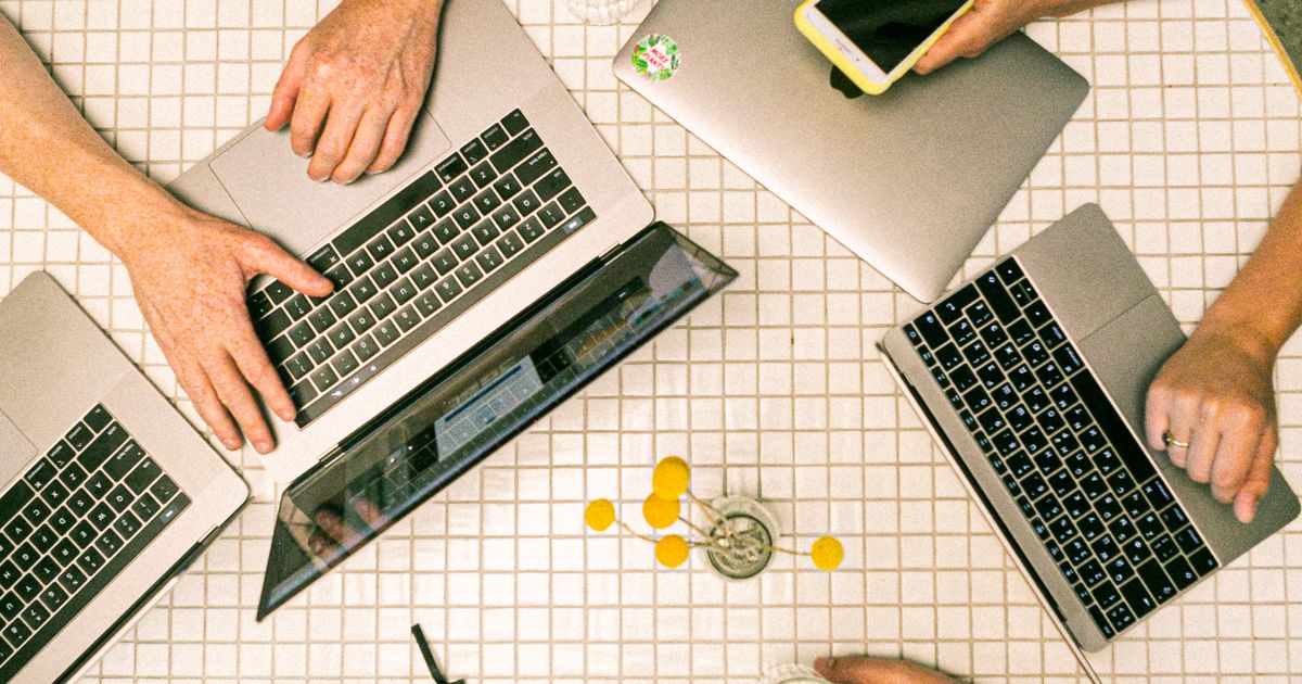 A marketing agency team collaborating on laptops