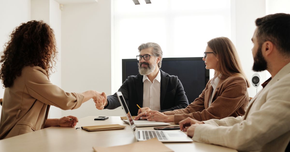An interview handshake across a meeting table
