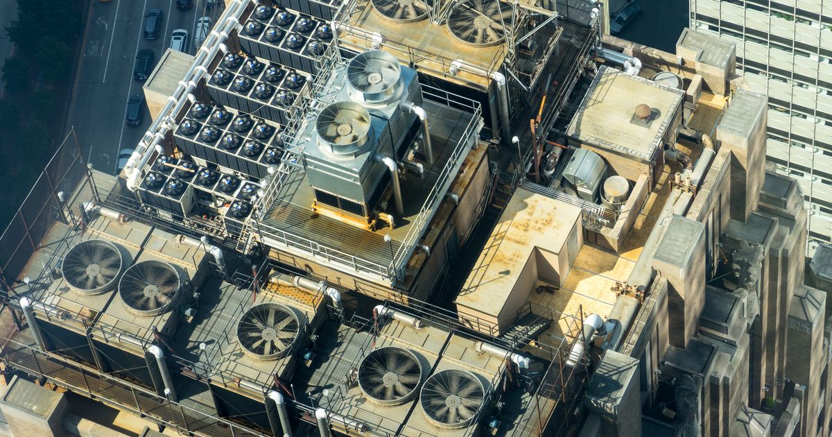Une rangée de groupes de climatisation sur le toit d'un immeuble commercial